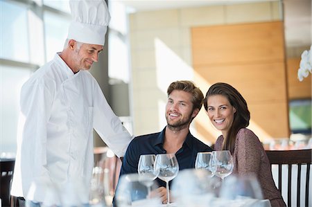 Chef talking to couple at restaurant Foto de stock - Sin royalties Premium, Código: 6108-06907877