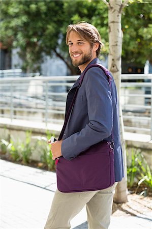 simsearch:6108-06906119,k - Portrait of a man walking on a street and smiling Stockbilder - Premium RF Lizenzfrei, Bildnummer: 6108-06908140