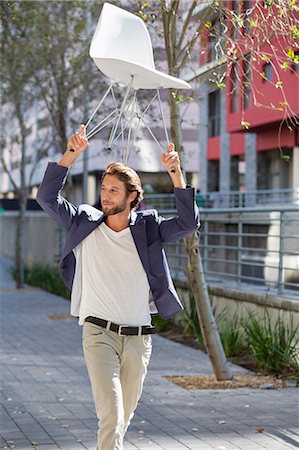 Man walking on a street with a chair Stock Photo - Premium Royalty-Free, Code: 6108-06908149