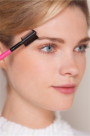 face makeup - Beautiful woman brushing her eyebrow Stock Photo - Premium Royalty-Free, Code: 6108-07969460