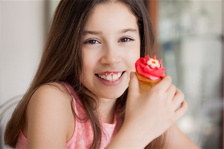 simsearch:6108-06167275,k - Happy girl eating cupcake Foto de stock - Sin royalties Premium, Código: 6108-07969545