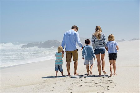 five children holding hands - Rear view of a family walking on the beach Stock Photo - Premium Royalty-Free, Code: 6108-08662365