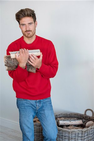 firewood - Young man holding firewood at home Stock Photo - Premium Royalty-Free, Code: 6108-08662392