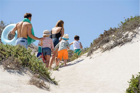 simsearch:6108-08662377,k - Rear view of a family walking on the beach Photographie de stock - Premium Libres de Droits, Code: 6108-08662334