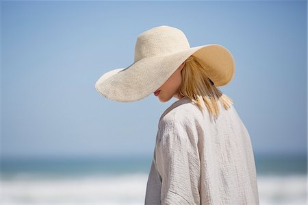 simsearch:6108-07969446,k - Beautiful young woman wearing sunhat on beach Foto de stock - Sin royalties Premium, Código: 6108-08662430