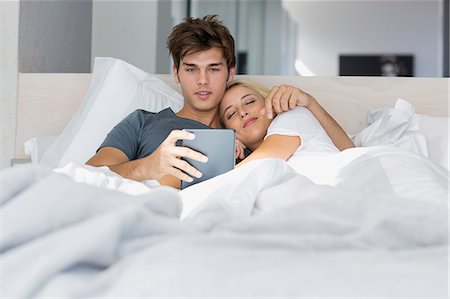 Couple watching movie on digital tablet on the bed Photographie de stock - Premium Libres de Droits, Code: 6108-08662540