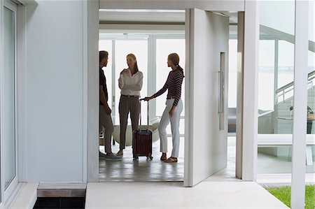 Woman talking to her friends arrived at her home Photographie de stock - Premium Libres de Droits, Code: 6108-08662522