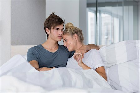 simsearch:6108-06166423,k - Happy young couple relaxing on the bed Fotografie stock - Premium Royalty-Free, Codice: 6108-08662528