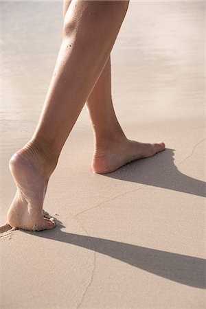 Low section view of a woman walking on the beach Photographie de stock - Premium Libres de Droits, Code: 6108-08662647