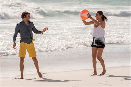 simsearch:6108-08662619,k - Happy young couple playing with a beach ball Stock Photo - Premium Royalty-Free, Code: 6108-08662664