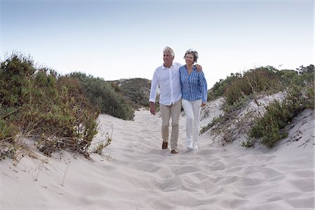Happy senior couple walking on beach Stock Photo - Premium Royalty-Free, Code: 6108-08662691
