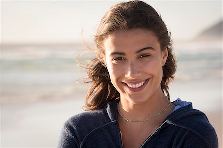 smiling young woman close up - Portrait of a happy beautiful young woman on the beach Stock Photo - Premium Royalty-Free, Code: 6108-08662627