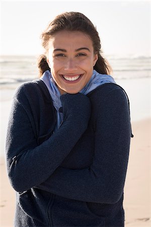 portrait of a beautiful young woman smile - Beautiful young woman standing o the beach Foto de stock - Sin royalties Premium, Código: 6108-08662631