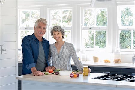 retired in front of house - Happy senior couple preparing food in kitchen Stock Photo - Premium Royalty-Free, Code: 6108-08662746