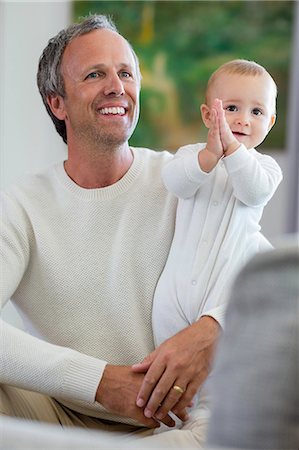 Happy father with his cute baby daughter in living room Stock Photo - Premium Royalty-Free, Code: 6108-08662751