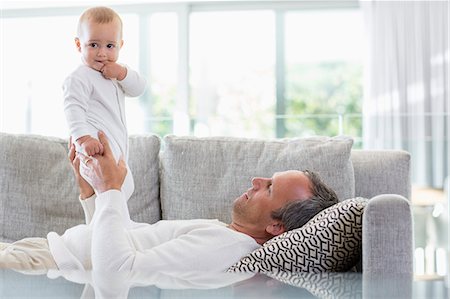 simsearch:6108-08663387,k - Happy father playing with his cute baby daughter at home Photographie de stock - Premium Libres de Droits, Code: 6108-08662757