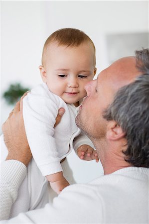 simsearch:6108-08663387,k - Happy father loving his cute baby daughter at home Photographie de stock - Premium Libres de Droits, Code: 6108-08662761