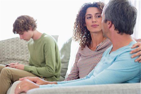 Happy family sitting in a living room at home Photographie de stock - Premium Libres de Droits, Code: 6108-08662771