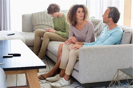 simsearch:6108-08663288,k - Happy family sitting in a living room at home Stock Photo - Premium Royalty-Free, Code: 6108-08662772