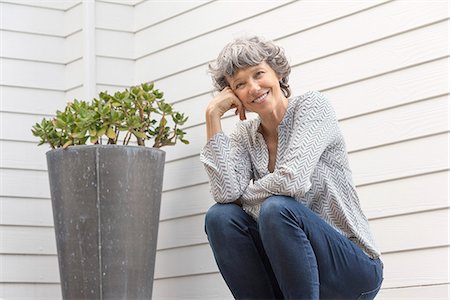 simsearch:6108-08663171,k - Happy woman sitting outside of house Stock Photo - Premium Royalty-Free, Code: 6108-08662739