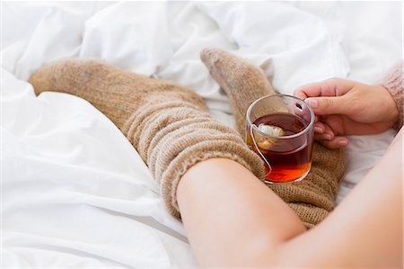 Close-up of a woman with cup of herbal tea in bed Photographie de stock - Premium Libres de Droits, Code: 6108-08662864