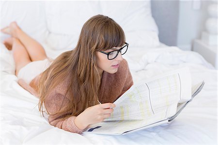 simsearch:6108-05873035,k - Woman reading a newspaper on the bed Stock Photo - Premium Royalty-Free, Code: 6108-08662873