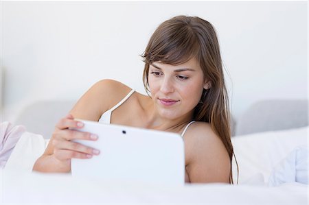 simsearch:6108-06904793,k - Beautiful young woman lying on the bed using a digital tablet Foto de stock - Sin royalties Premium, Código: 6108-08662882