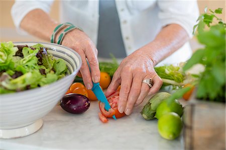 senior citizen close up - Senior woman cutting vegetables in kitchen Stock Photo - Premium Royalty-Free, Code: 6108-08662801