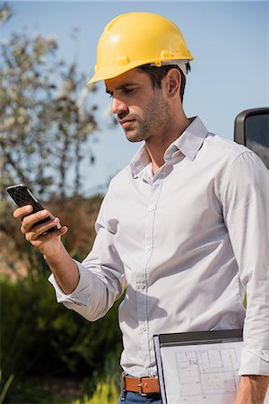 simsearch:6108-06166956,k - Male engineer using a mobile phone at site Stock Photo - Premium Royalty-Free, Code: 6108-08662945