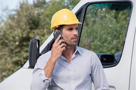 Male engineer talking on a mobile phone by van at site Stock Photo - Premium Royalty-Free, Code: 6108-08662948