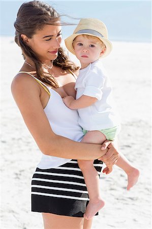 simsearch:6108-08663086,k - Beautiful woman carrying her son on the beach Foto de stock - Royalty Free Premium, Número: 6108-08663079