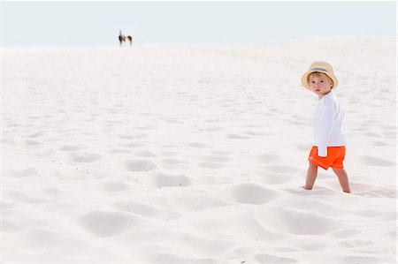 simsearch:6108-08663086,k - Baby boy standing on the beach Foto de stock - Royalty Free Premium, Número: 6108-08663087