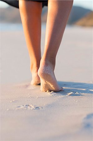 simsearch:6108-08662630,k - Low section view of woman walking on the beach Stock Photo - Premium Royalty-Free, Code: 6108-08663020