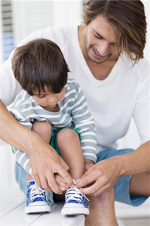 Father tying son's shoelaces at home Photographie de stock - Premium Libres de Droits, Code: 6108-08663157