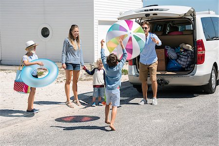 Happy young family packing car with beach gears for vacation Stock Photo - Premium Royalty-Free, Code: 6108-08663179