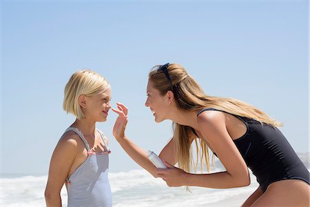 Beautiful woman applying sunscreen on her daughter face Stock Photo - Premium Royalty-Free, Code: 6108-08663197