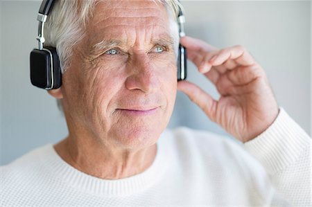 simsearch:6108-08725387,k - Senior man listening to music on headphones Stock Photo - Premium Royalty-Free, Code: 6108-08663111