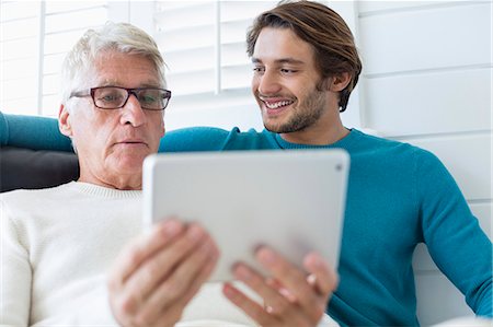 simsearch:400-05736257,k - Happy father and son using digital tablet in living room Stock Photo - Premium Royalty-Free, Code: 6108-08663120