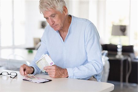 person counting money image - Senior man counting currency note son table Stock Photo - Premium Royalty-Free, Code: 6108-08663126