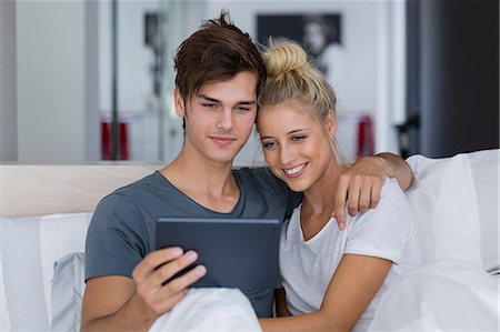 simsearch:6108-06166423,k - Young couple taking a selfie on the bed Fotografie stock - Premium Royalty-Free, Codice: 6108-08663250