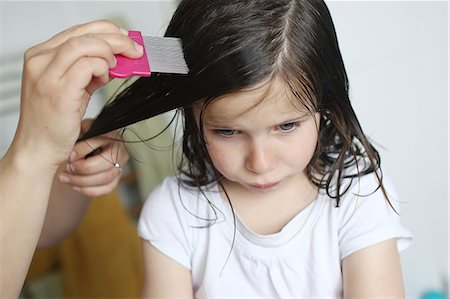 faire la moue - A mother passes a lice comb in the hair of her 6 years old girl Photographie de stock - Premium Libres de Droits, Code: 6108-08636941