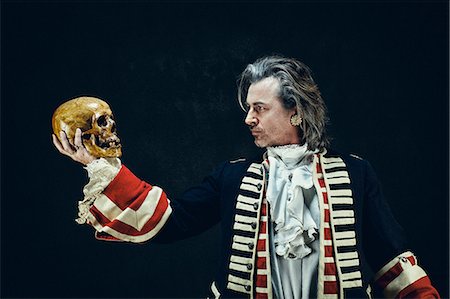 Officer in uniform "dragons", in profile, holding a skull in his hand Photographie de stock - Premium Libres de Droits, Code: 6108-08637276