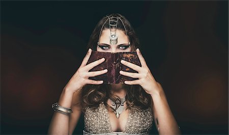 política - Portrait of a young tribal woman holding an old book in his face - Styling "Sanhadja" Foto de stock - Sin royalties Premium, Código: 6108-08637383