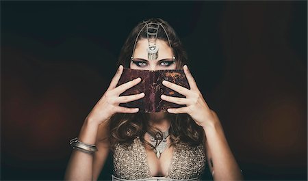 fantasy animal - Portrait of a young tribal woman holding an old book in his face - Styling "Sanhadja" Stock Photo - Premium Royalty-Free, Code: 6108-08637383