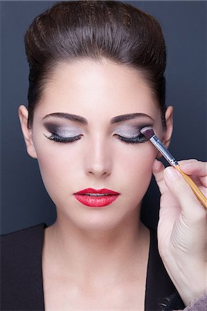simsearch:6108-08637392,k - Portrait of a young woman doing makeup, eyes closed Fotografie stock - Premium Royalty-Free, Codice: 6108-08637385