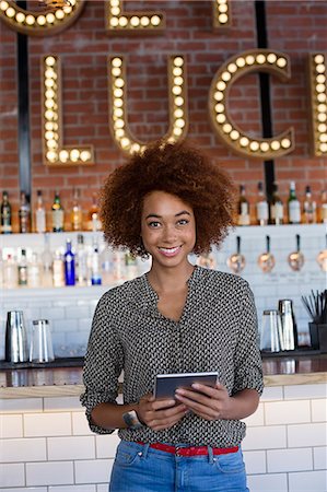 restaurant owner tablet - Portrait of happy young woman with a digital tablet at bar counter Stock Photo - Premium Royalty-Free, Code: 6108-08725141