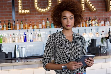 restaurant owner tablet - Young woman with a digital tablet at bar counter Stock Photo - Premium Royalty-Free, Code: 6108-08725275