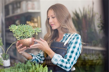 Woman holding a potted plant in flower shop Photographie de stock - Premium Libres de Droits, Code: 6108-08725357