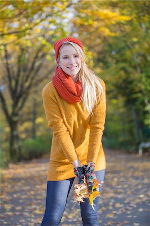 simsearch:6108-08943478,k - Pretty blonde woman with leaves in park in autumn Photographie de stock - Premium Libres de Droits, Code: 6108-08943511