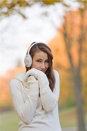 simsearch:6108-08943515,k - Portrait of a beautiful young woman smiling in the park in Autumn with earmuffs Foto de stock - Sin royalties Premium, Código: 6108-08908950